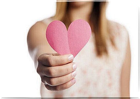 Woman holding pink paper heart