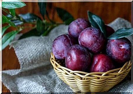 A basket with purple plums.