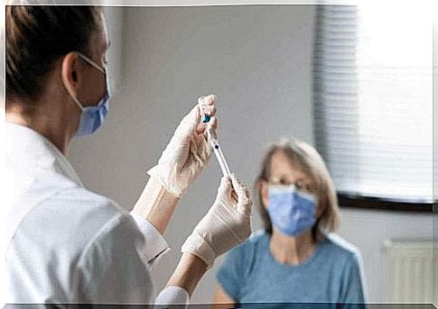 A doctor prepares a syringe.