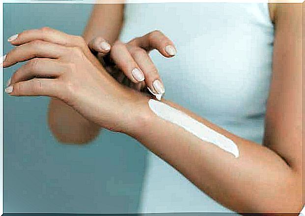 A woman applying cream on her arm