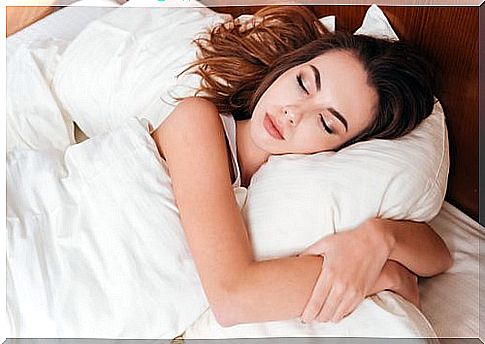 Woman sleeping and holding around her pillow