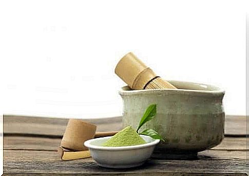 A small bowl of matcha tea next to a larger bowl.